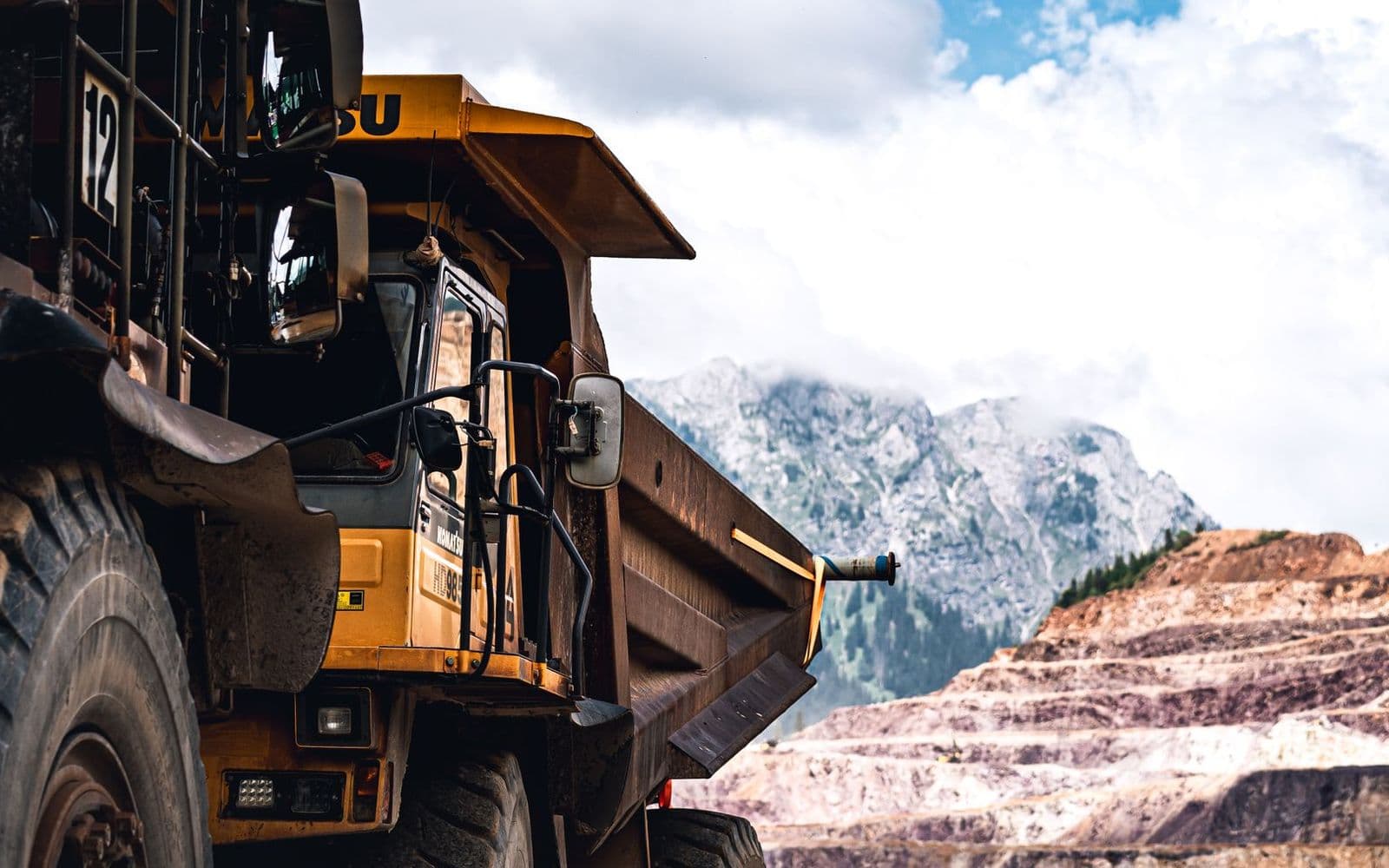 Large mining haul truck in front of a mountain pit