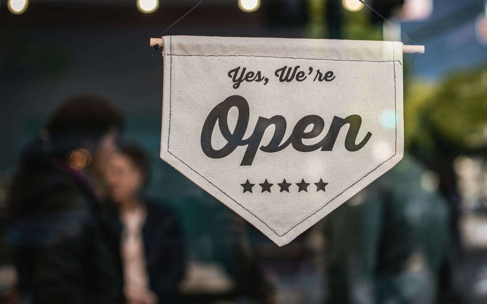 Open sign hanging in a shop window